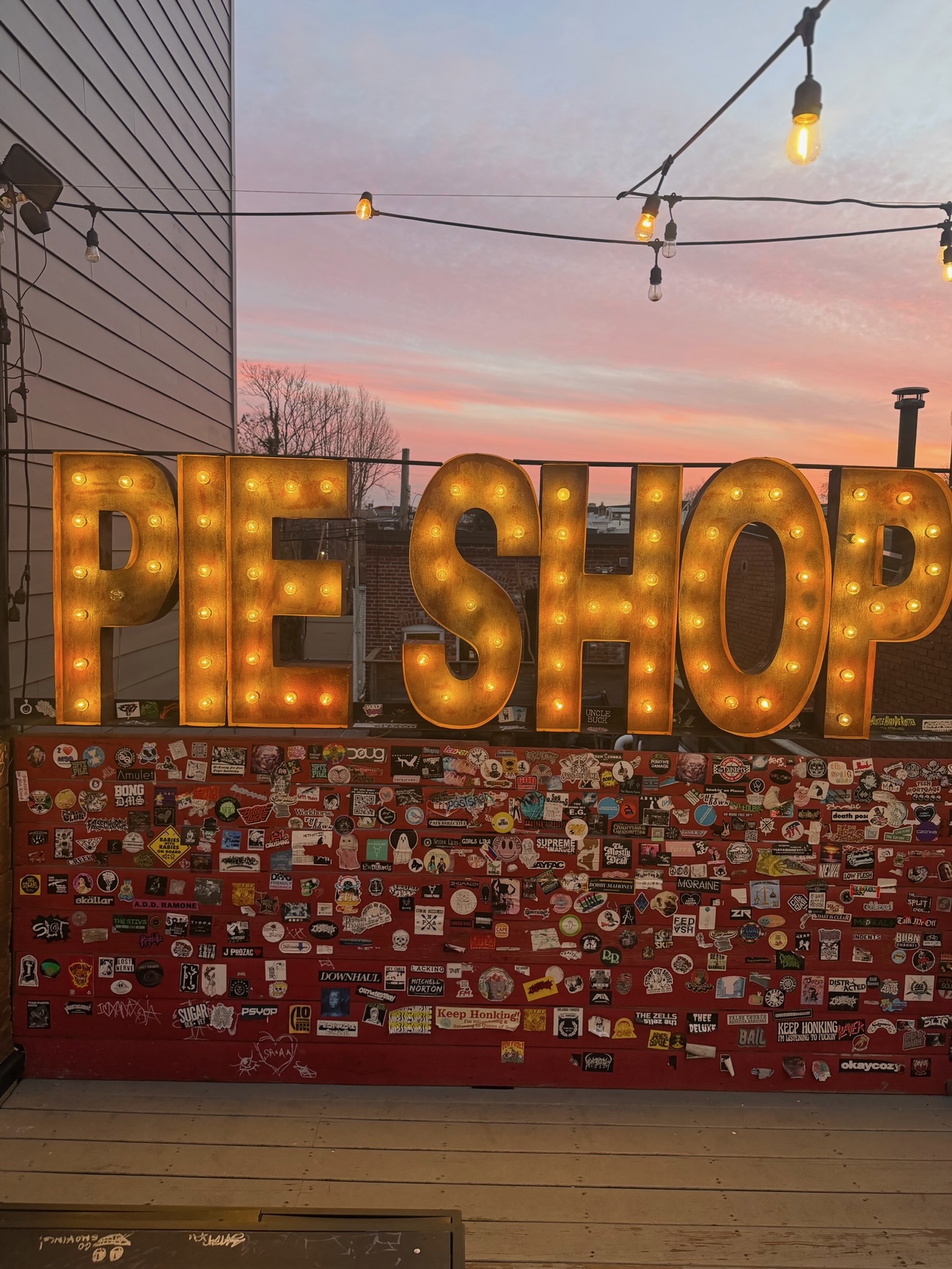 The illuminated Pie Shop sign at sunset